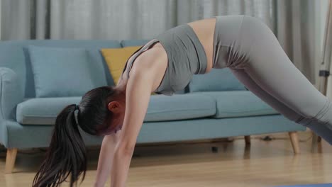 young asian trainer female in sports clothes speaking and stretching while teaching exercise at home