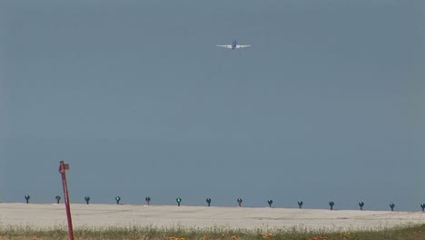 a jet airplane lands as another jet takes off at an airport