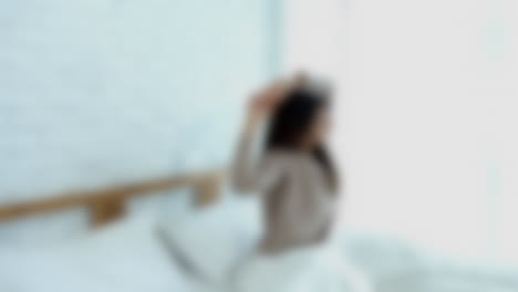 Blurred-shot-of-woman-waking-up-and-stretching-in-bed-in-the-morning