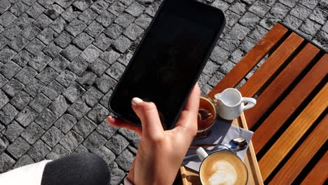 Una-Chica-Toma-Fotos-De-Una-Mesa-De-Madera-Al-Aire-Libre-Con-Tazas-De-Café-Con-Leche-Y-Hielo