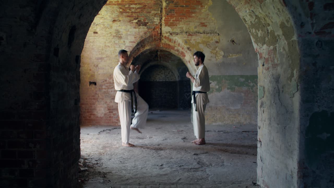 Due uomini che praticano karate tra le rovine