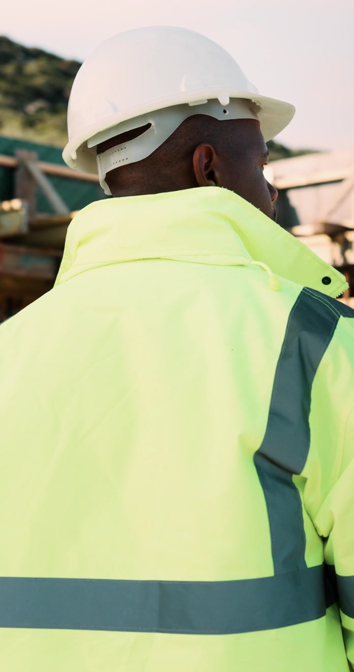 Trabajador de la construcción poniéndose un casco de seguridad blanco
