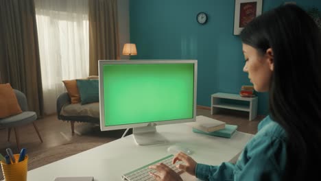 woman working on computer with green screen