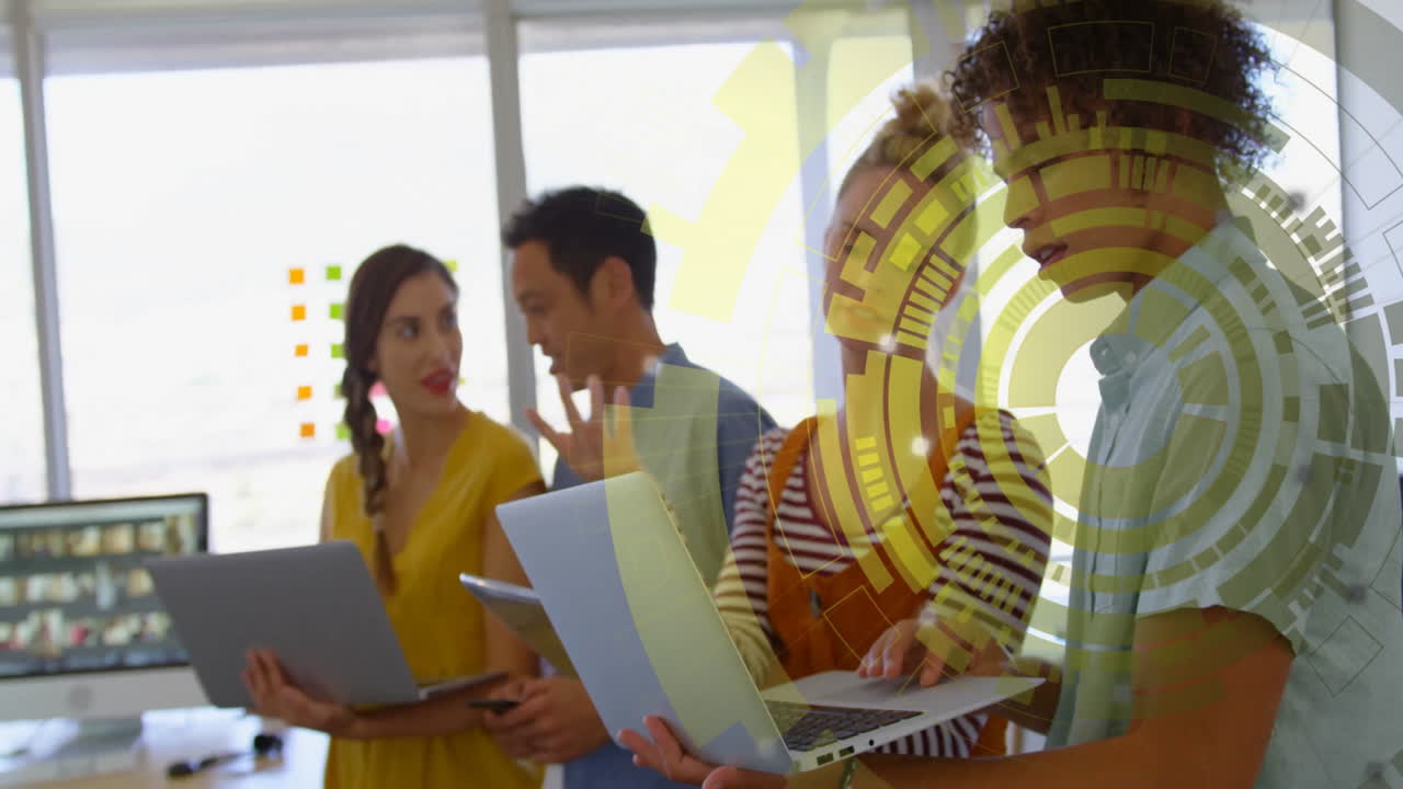 Diverse team using laptops with digital data processing animation overlay