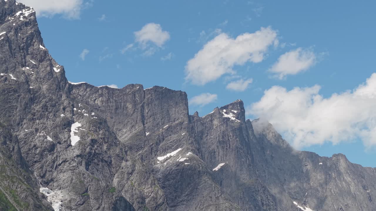 Trollveggen, Norveç – Dik Kayalık Duvarlar, Süzülen Bulutlarla Mavi Bir Gökyüzüne Karşı Dramatik Bir Şekilde Yükseliyor – Yakın Çekim