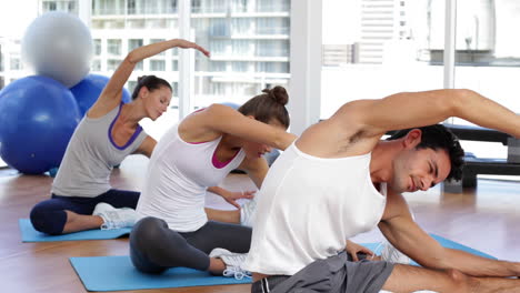 clase de yoga estirando sus piernas