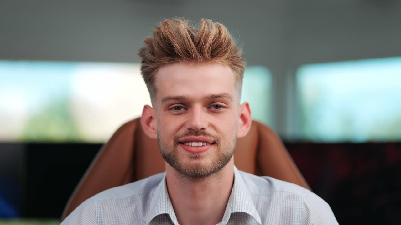 Executive Confidence: Young Businessman Looks Directly at Camera in Modern Office, Close-Up Shot as Camera Approaches