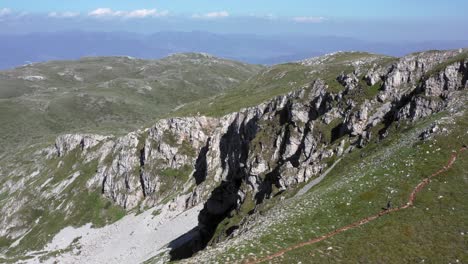 Stunning-cinematic-aerial-drone-shot-of-Rocky-Mountains-of-Galičica-National-Park-with-blue-skies,-fluffy-clouds-and-greenery