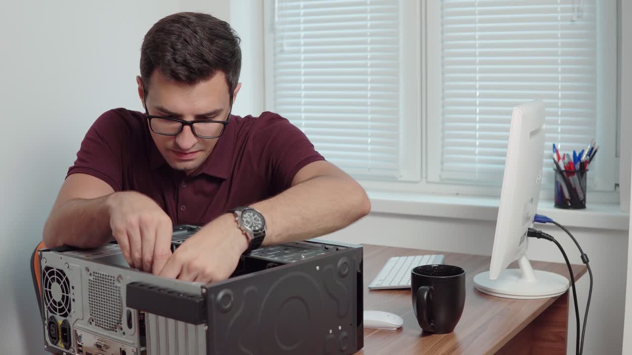Young professional worker repair a broken computer in the office using a screwdriver and upgrading computer hardware. Support team. Computer maintenance. Shot in 4k