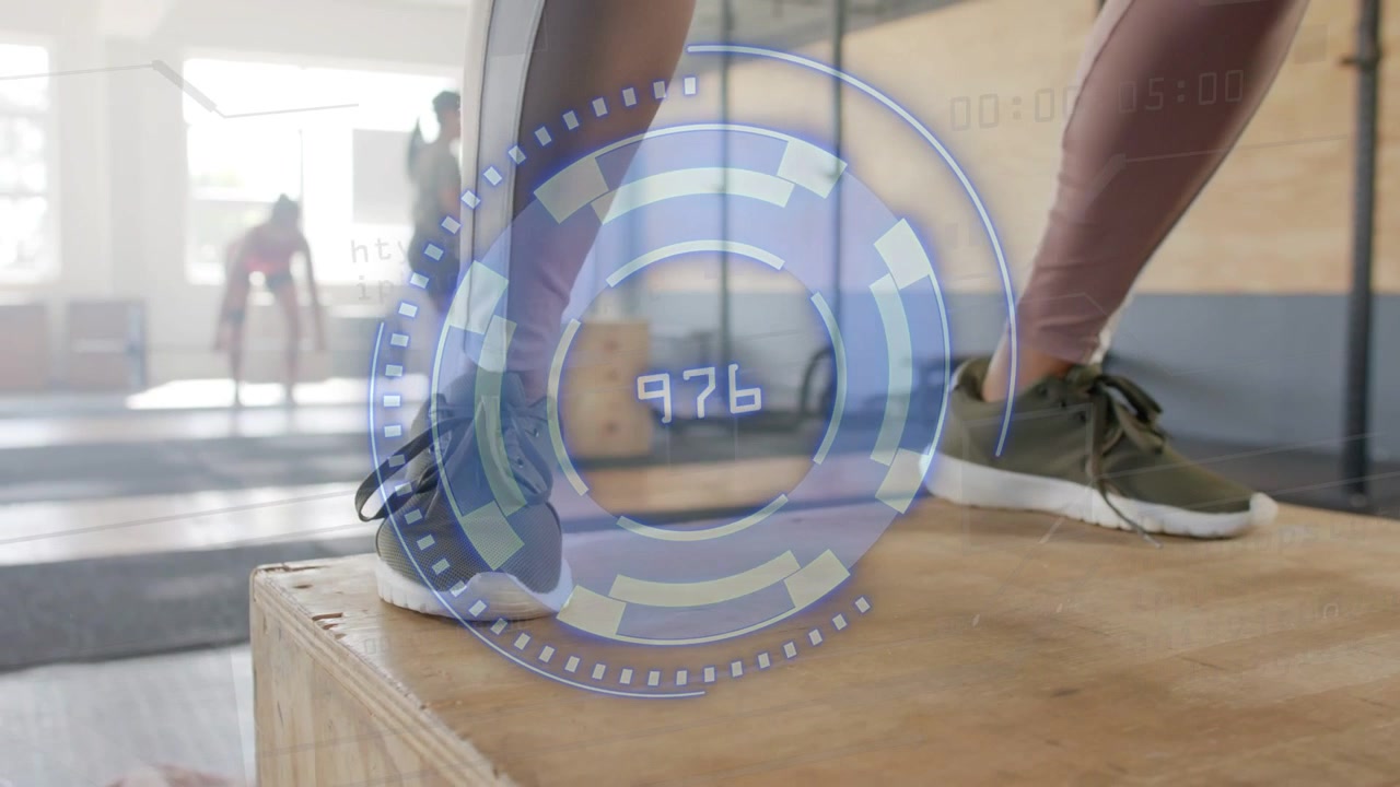 Female trainee stepping onto plyo box in gym, HUD updating three-digit readouts tracking effort