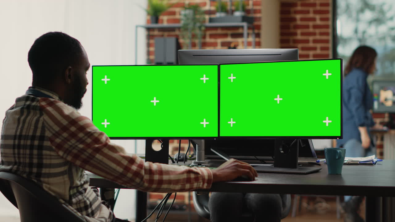 African american man analyzing greenscreen on multi monitors