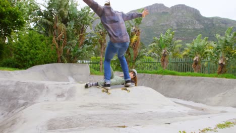 Vista-Trasera-De-Un-Joven-Caucásico-Haciendo-Truco-De-Skate-En-Rampa-En-El-Parque-De-Skate-4k