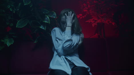 woman posing on a couch in a neon lit room