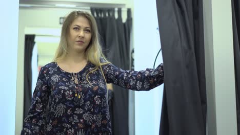 una chica hermosa en el vestuario se examina a sí misma.