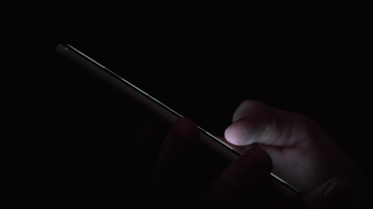 reflejo de la pantalla en el ojo verde azul de la persona en una habitación oscura 15