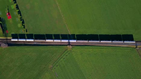 Tren-Estacionario-Con-Vista-Aérea-Sentado-En-Vías-En-Campo-Verde-Con-Sombras