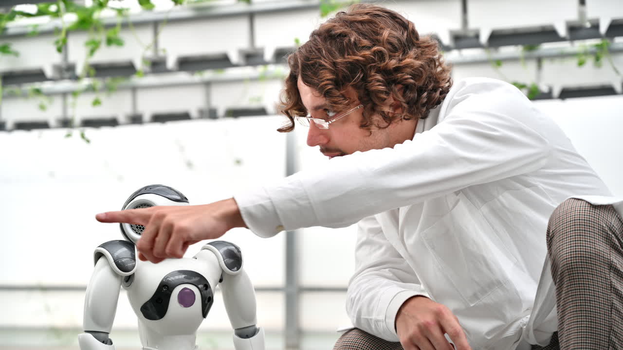 Laboratory technician in a white coat interacting with humanoid robot in a greenhouse farm