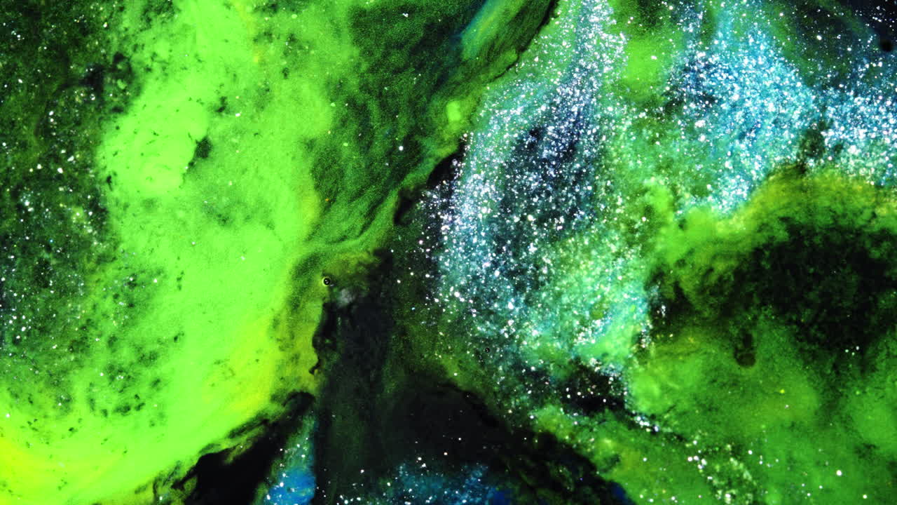 Colorful fluids blend in macro view, forming cosmic patterns and dreamy textures