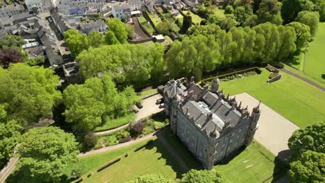 ascending aerial video of glenarm castle grounds, in county antrim, northern ireland, uk on a bright and sunny day. filmed in 4k, 60fps and with rec709 color.