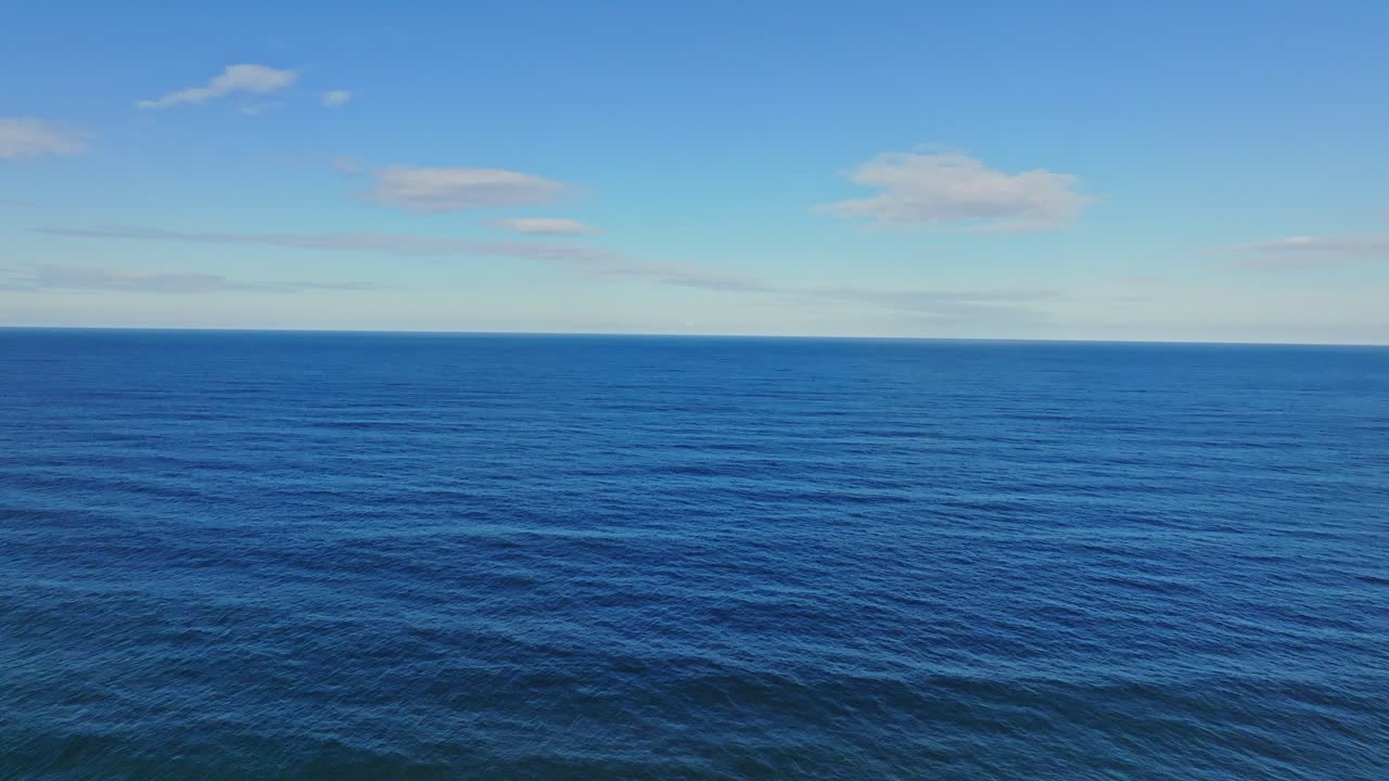 "Drone footage of the blue open Atlantic ocean horizon, showcasing the vast expanse of the sea."