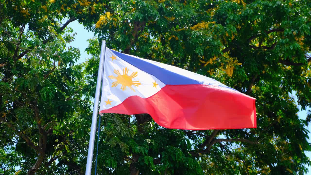 Closeup of national flag of the Philippines flying in wind in capital city of Manila