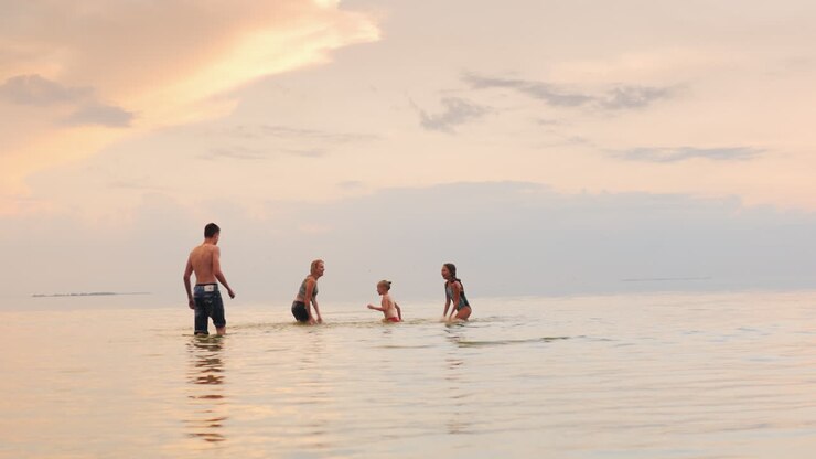 Children And Adults Play In The Water Laughing Splash Worm Water At Each Other