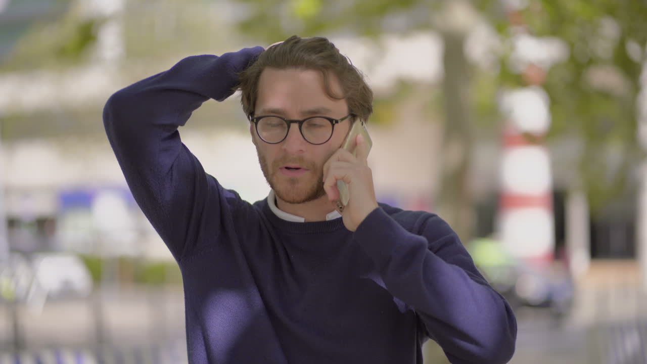 hombre pensativo hablando por teléfono celular al aire libre