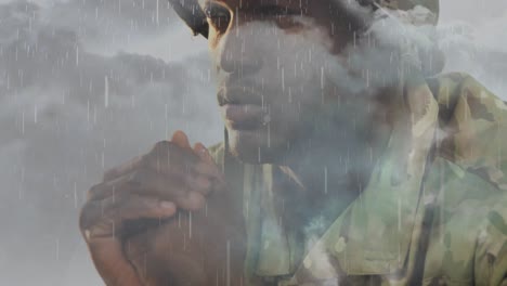 Animation-of-clouds-and-rain-over-sad-african-american-male-soldier