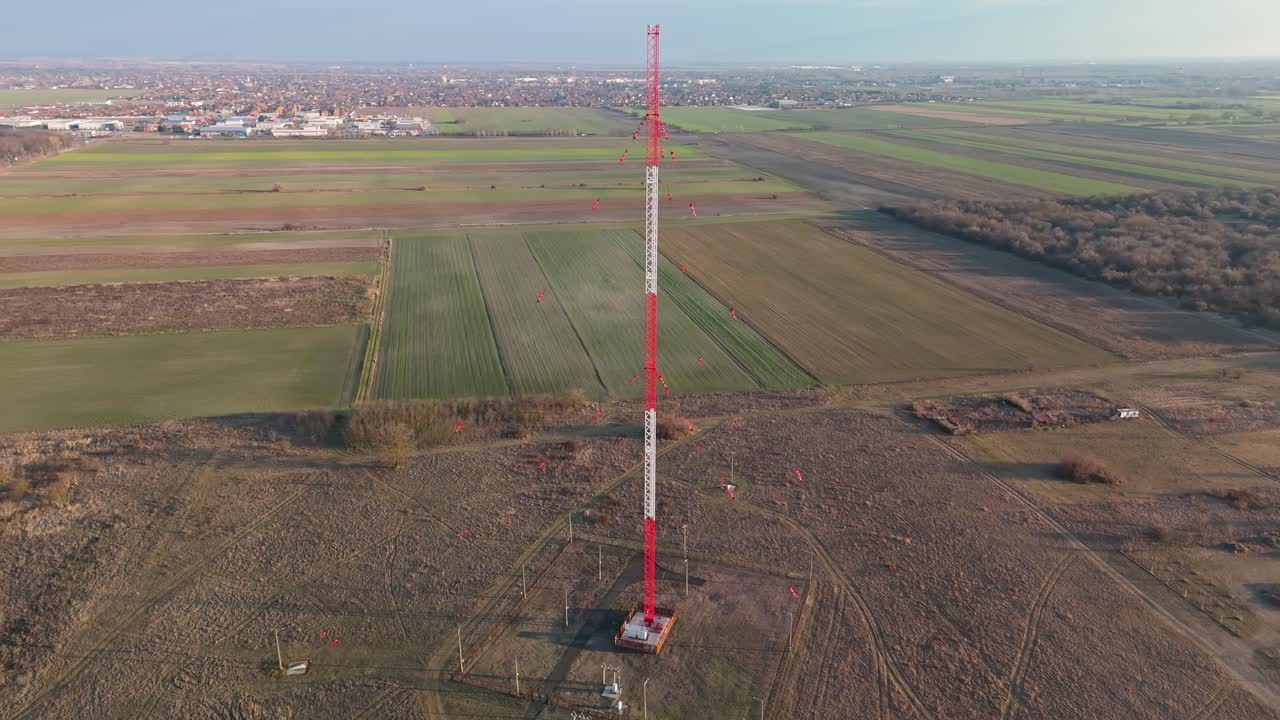 Lakihegy, near Szigetszentmiklós in Budapest, Hungary, features a prominent guyed steel radio mast used for medium-wave broadcasting, captured from above in a bird's-eye view of the urban landscape