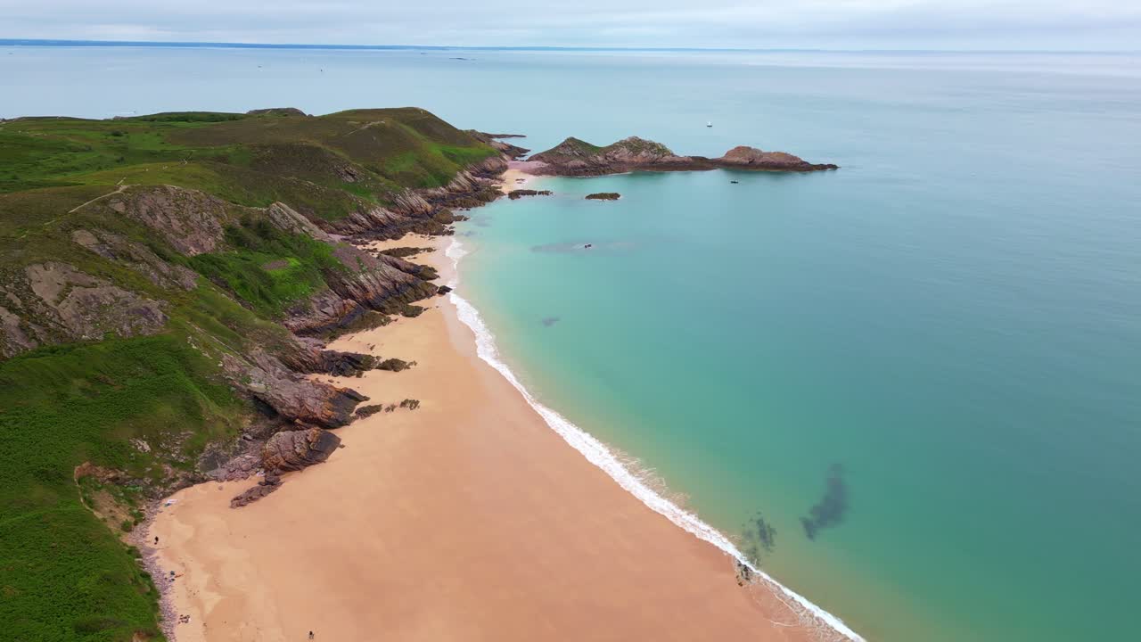 Wide drone view of the pristine Cap d'Erquy tropical beach side in calm bay, Côtes-d'Armor, Brittany, France.