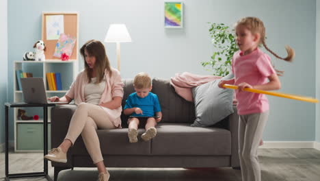 mujer en casa con hijos trabaja de forma remota en internet en la computadora