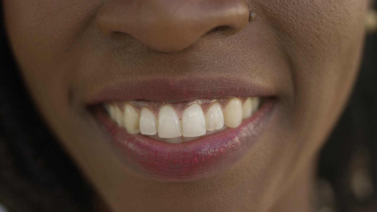 un primer plano de una mujer afroamericana con una sonrisa dentada.