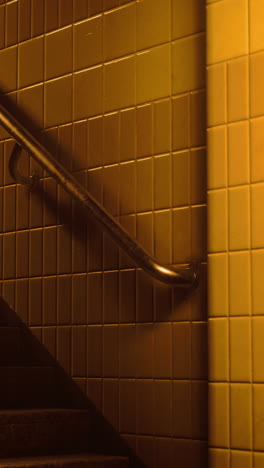 stairwell with gold tiles and handrail