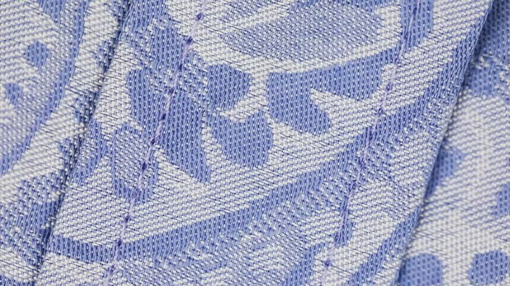 Macro Shot Of Blue And White Knitted Garment With Black Button