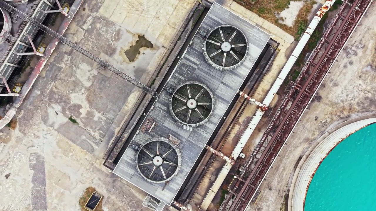 View of industrial cooling units on rooftop in an urban area during daylight