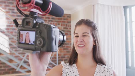 caucasian vlogger woman doing a video at home