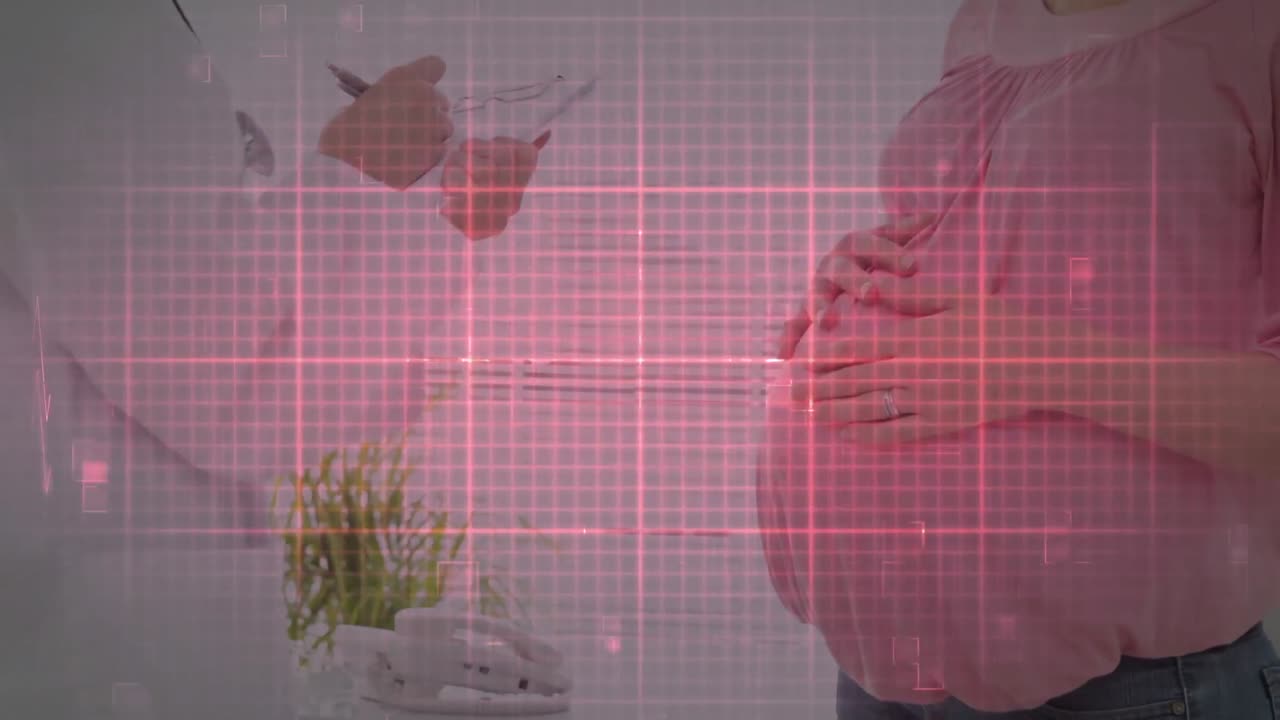 심장 박동 모니터를 통해 백인 남성 의사가 메모를 하고 여성 환자가 임신하는 배를 만지고 있습니다.