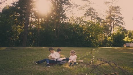 schoolchildren-sit-on-green-meadow-during-school-break