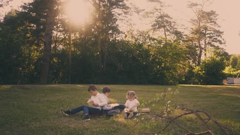 schoolchildren sit on green meadow during school break