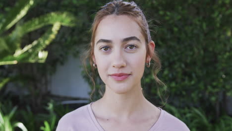 happy caucasian woman standing and smiling in sunny garden,slow motion