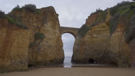 Praia-dos-estudantes-beach-with-arch-bridge-in-Lagos,-Portugal