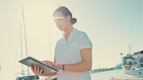 yacht, tablet and sailing with woman on pier