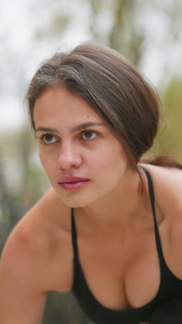 Close-up view of focused woman preparing for sprint, intense concentration, athletic workout, fitness training, determination, ready to run, outdoor exercise, strong mindset, focus before race