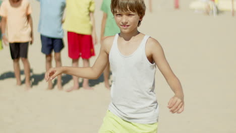 Vertical-motion-of-pretty-boy-standing-with-knee-on-soccer-ball