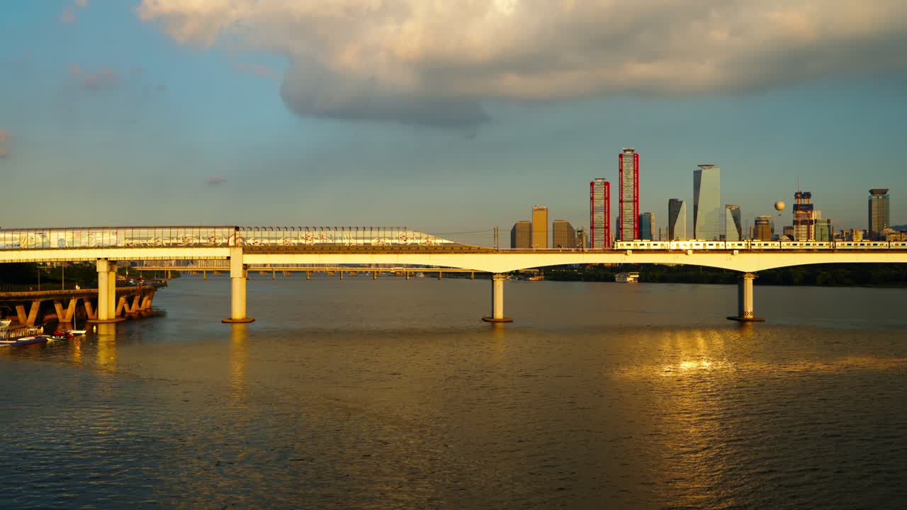Seoul subway Line 2 train travels from Hapjeong station, crossing the Dangsan Railway Bridge over the Han River with the Yeouido skyline at sunset