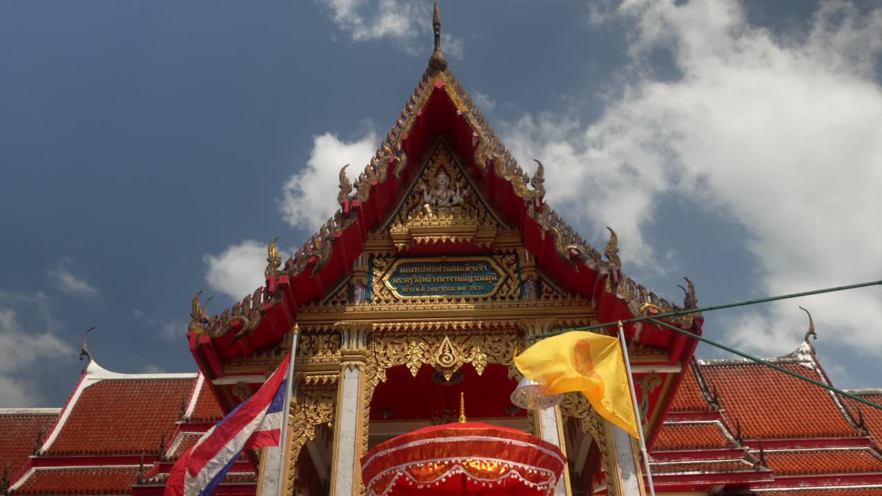 Tempio di Chalong, Thailandia, e bandiere buddiste che sventolano sulla facciata del tempio Wat Chaithararam
