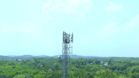 telecommunication tower with 5g cellular network antenna on green trees background