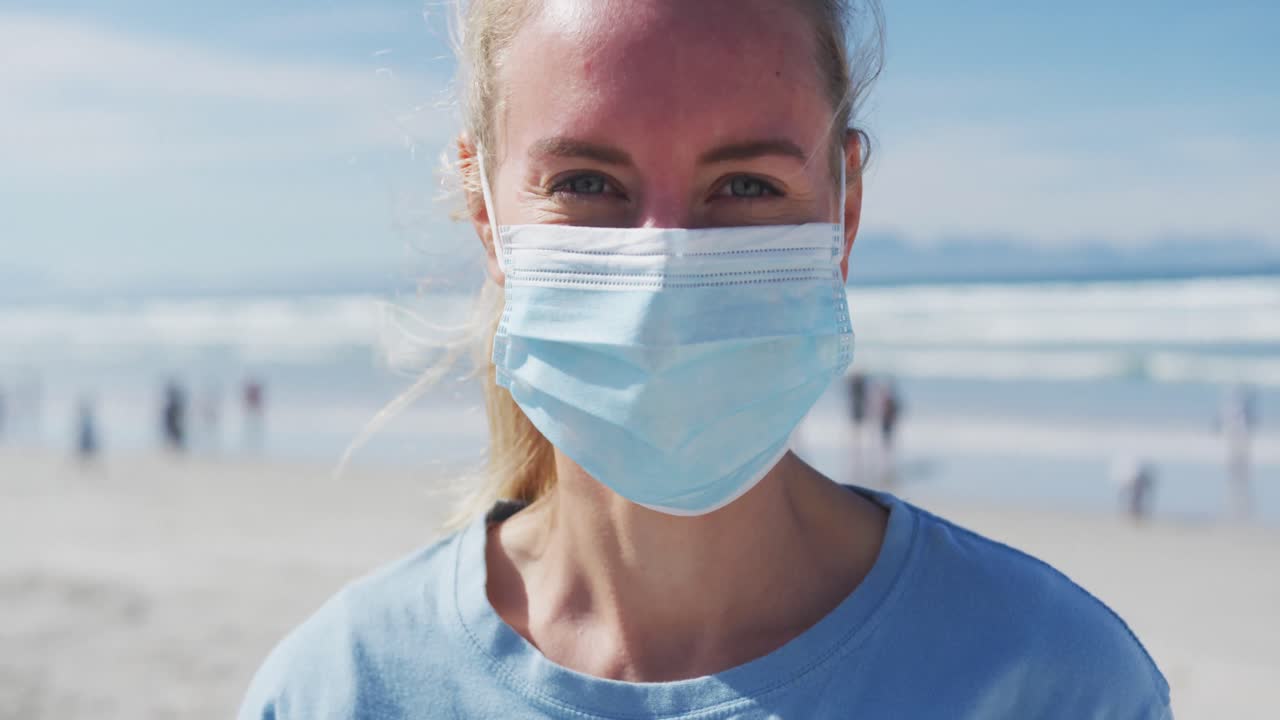 카메라 를 바라보는 자원 봉사자 티셔츠 와 얼굴 마스크 를 입은 백인 여성 의 초상화