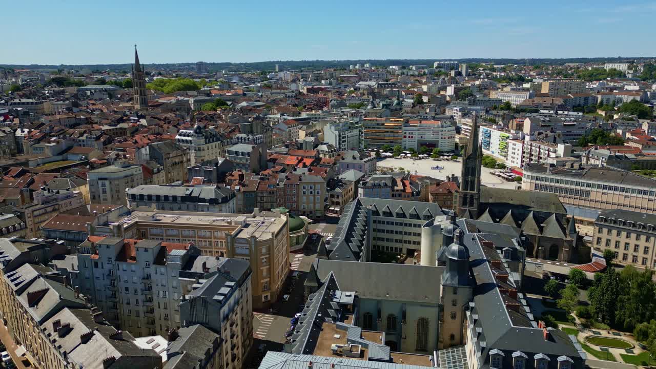 Drone pullback over rooftops in Limoges with churches and distant basilica visible, sunny clear sky