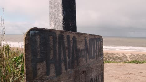Wooden-sign-on-sandy-beach-with-North-Beach-sign-in-Portuguese